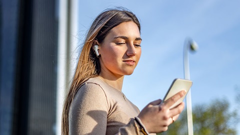 jonge vrouw draagt true wireless oortjes